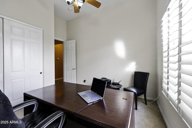 carpeted home office featuring baseboards and a ceiling fan
