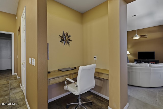 office area featuring baseboards, ceiling fan, and built in study area