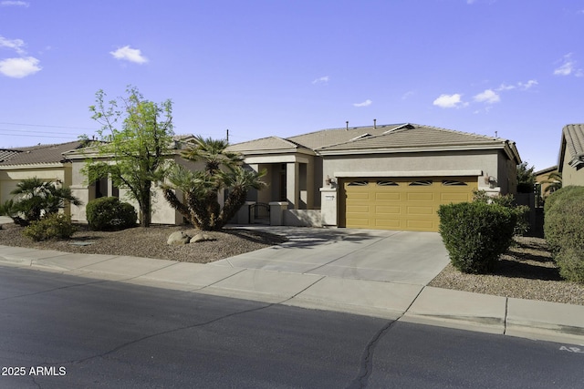 view of front of property featuring driveway, an attached garage, a tiled roof, and stucco siding