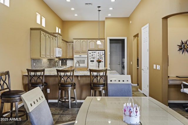 kitchen featuring tasteful backsplash, recessed lighting, white appliances, a peninsula, and visible vents