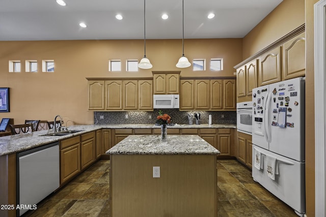 kitchen with plenty of natural light, a sink, stone finish floor, white appliances, and backsplash
