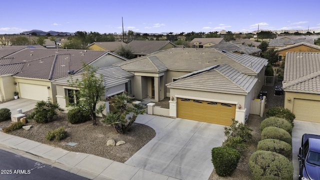 view of front of house with an attached garage, stucco siding, a residential view, and concrete driveway