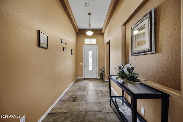 doorway featuring visible vents, baseboards, and a textured wall