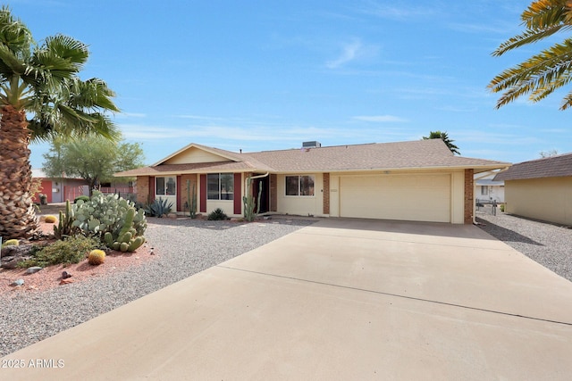 single story home featuring concrete driveway and an attached garage