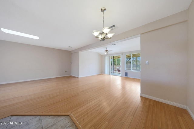 unfurnished room with a skylight, visible vents, baseboards, a ceiling fan, and light wood-style floors