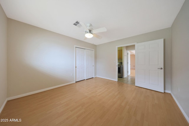 unfurnished bedroom featuring a ceiling fan, visible vents, baseboards, a closet, and light wood finished floors