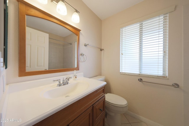 bathroom featuring tile patterned flooring, toilet, vanity, baseboards, and walk in shower