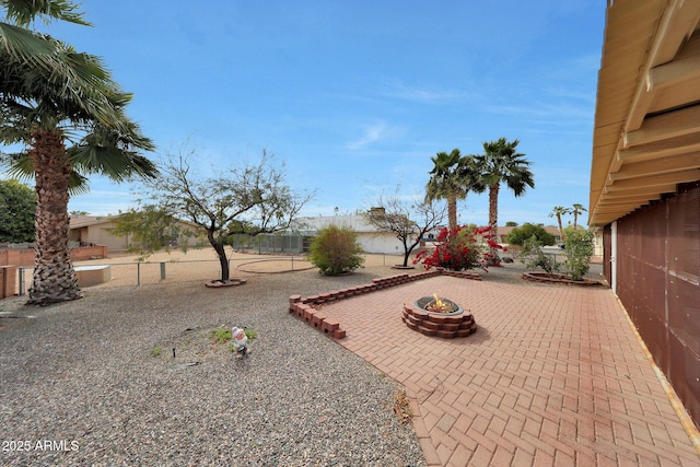 view of yard featuring a patio, an outdoor fire pit, and fence