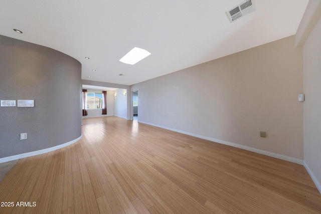 unfurnished living room with light wood-style flooring, visible vents, and baseboards