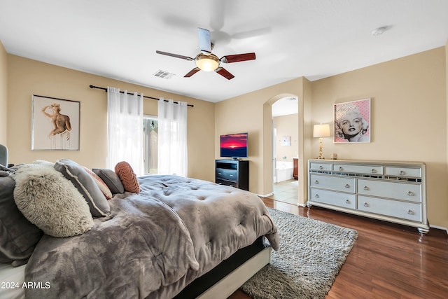 bedroom featuring ceiling fan, ensuite bathroom, and dark wood-type flooring