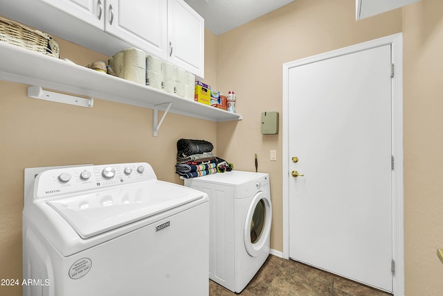 laundry area with cabinets, washing machine and clothes dryer, and dark tile floors