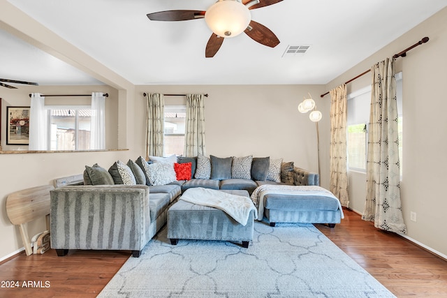 living room featuring ceiling fan and dark wood-type flooring