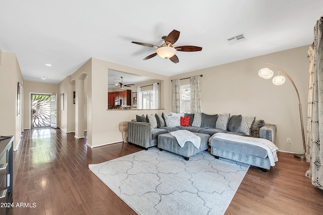 living room with ceiling fan and dark hardwood / wood-style flooring