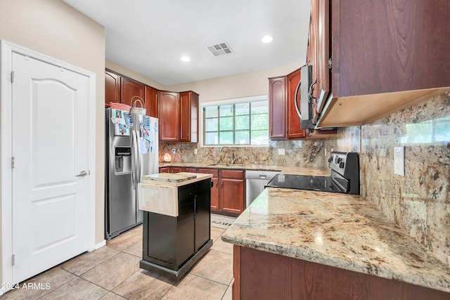 kitchen featuring light stone counters, backsplash, stainless steel appliances, and light tile flooring