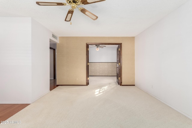 carpeted spare room with ceiling fan and a textured ceiling