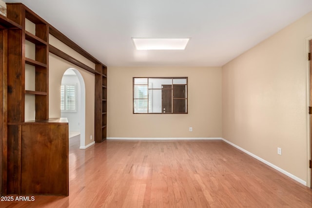 unfurnished room with built in features and light wood-type flooring