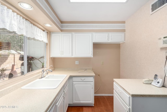 kitchen with white cabinetry, sink, wood-type flooring, and dishwasher