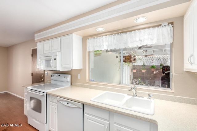 kitchen featuring hardwood / wood-style flooring, white cabinetry, sink, and white appliances