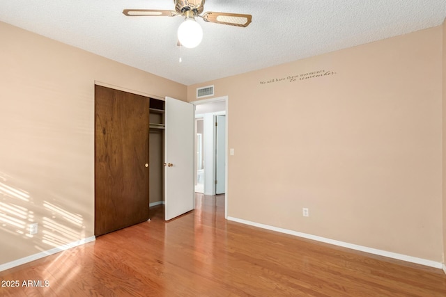 unfurnished bedroom featuring a closet, ceiling fan, a textured ceiling, and light hardwood / wood-style flooring