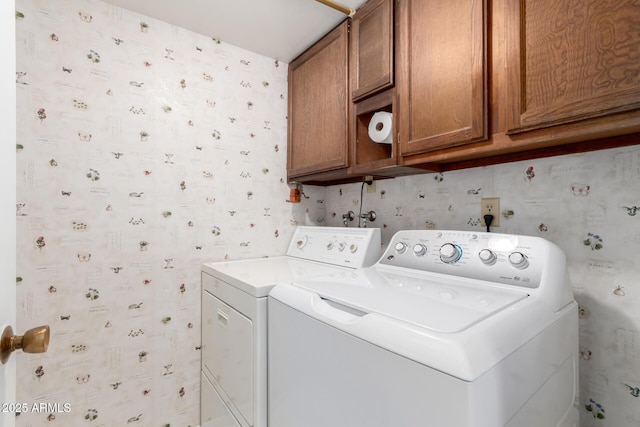 laundry area with independent washer and dryer and cabinets