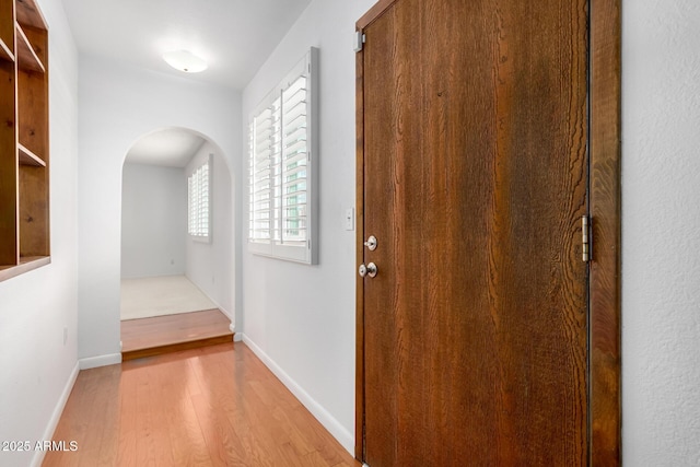 hallway with light hardwood / wood-style floors