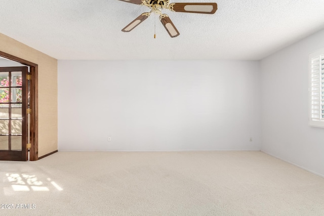 spare room with ceiling fan, light colored carpet, and a textured ceiling