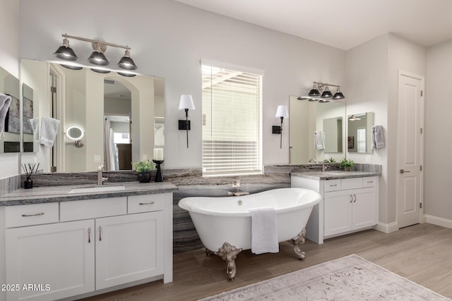 2605 S Quaintance St, Gilbert, AZ 85295 - full bathroom with wood finished floors, two vanities, and a freestanding bath
