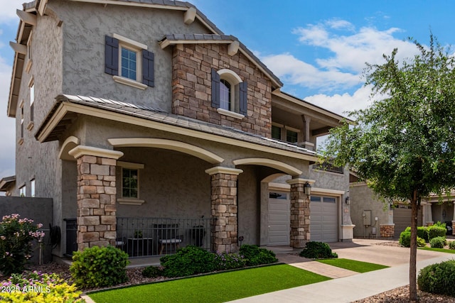 2605 S Quaintance St, Gilbert, AZ 85295 - view of front of home with stucco siding, a garage, a porch, driveway, and stone siding