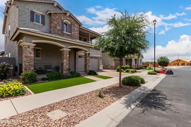 2605 S Quaintance St, Gilbert, AZ 85295 - view of front of home featuring stucco siding, stone siding, a porch, an attached garage, and concrete driveway