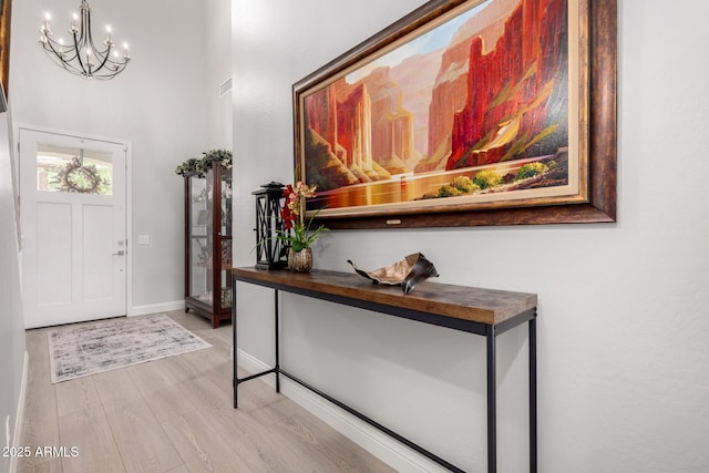 2605 S Quaintance St, Gilbert, AZ 85295 - entryway with a chandelier, light wood-style flooring, baseboards, and a high ceiling
