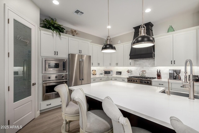 2605 S Quaintance St, Gilbert, AZ 85295 - kitchen with stainless steel appliances, tasteful backsplash, white cabinets, a breakfast bar area, and light countertops