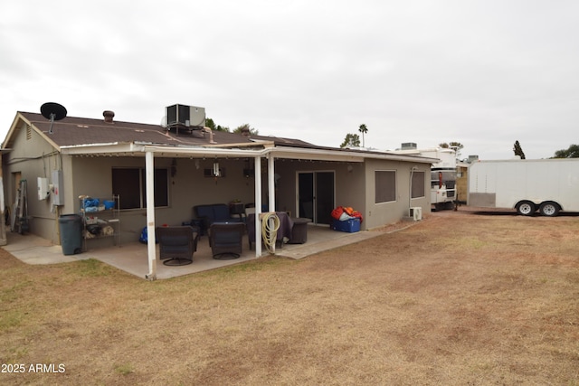 back of house featuring a yard, central AC unit, and a patio area