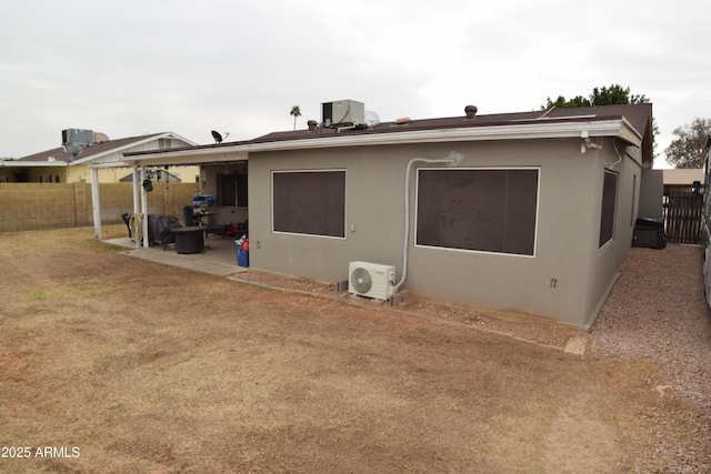 rear view of house with ac unit and a patio