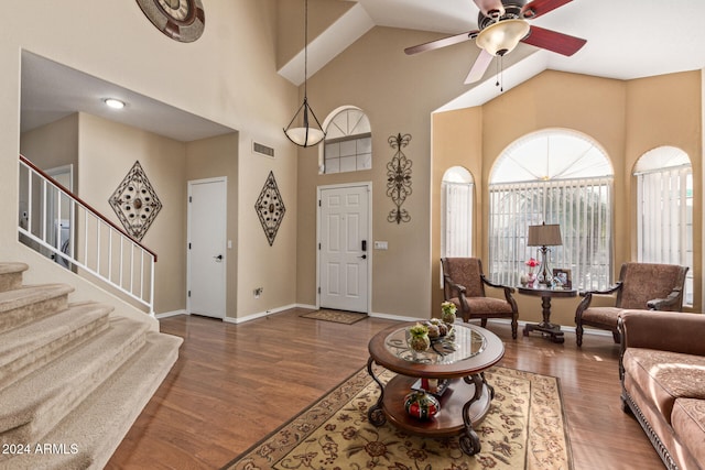 living room featuring dark hardwood / wood-style floors, ceiling fan, and high vaulted ceiling