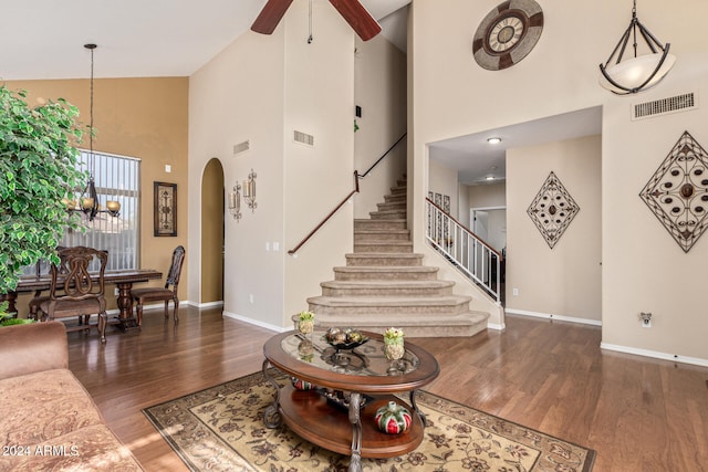 living room featuring dark hardwood / wood-style floors, high vaulted ceiling, and ceiling fan