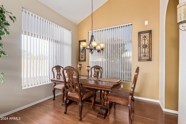 dining room with a notable chandelier, dark hardwood / wood-style flooring, and lofted ceiling