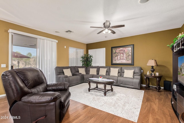 living room with hardwood / wood-style floors, ceiling fan, and a textured ceiling