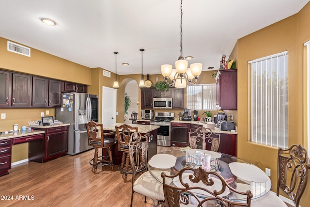 dining area with sink, light hardwood / wood-style floors, and a notable chandelier