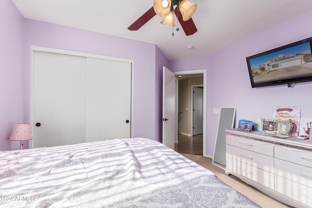 bedroom featuring ceiling fan, light colored carpet, and a closet