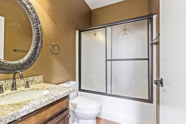 full bathroom featuring toilet, vanity, and combined bath / shower with glass door