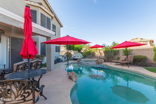 view of swimming pool featuring an in ground hot tub and a patio