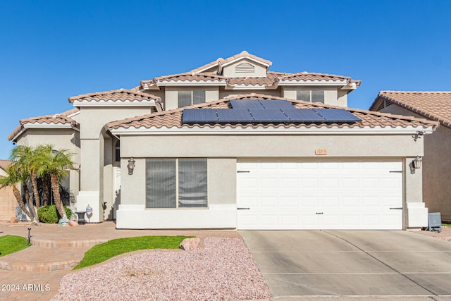 mediterranean / spanish-style home with solar panels and a garage