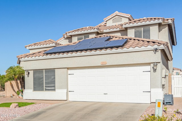 mediterranean / spanish house with a garage and solar panels