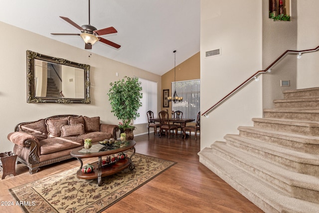 living room featuring hardwood / wood-style floors, ceiling fan with notable chandelier, and high vaulted ceiling