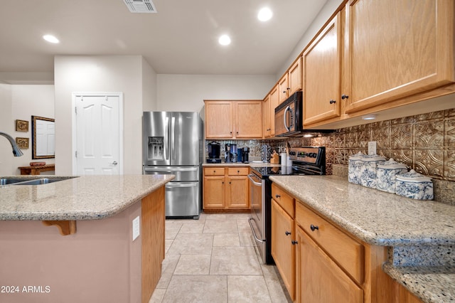 kitchen with decorative backsplash, light stone countertops, sink, and appliances with stainless steel finishes