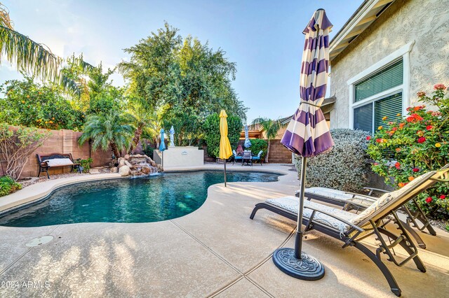 view of swimming pool featuring pool water feature and a patio area