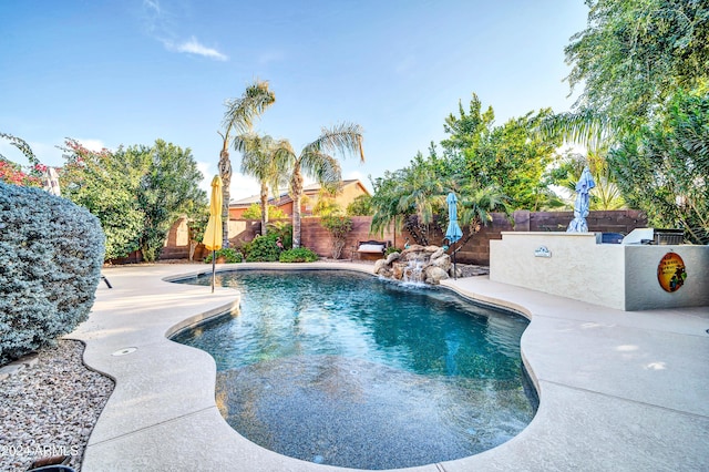 view of swimming pool with pool water feature and a patio