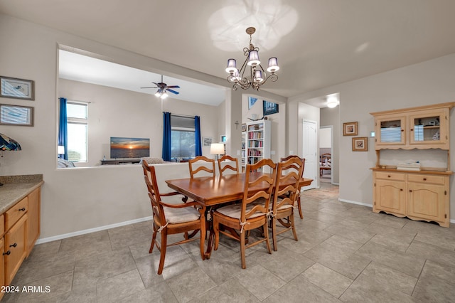 dining space with ceiling fan with notable chandelier