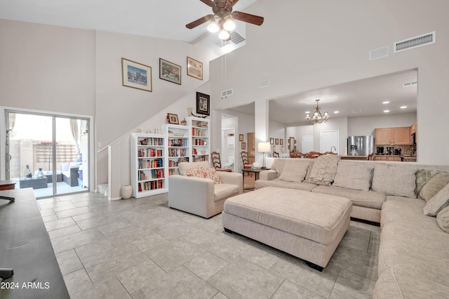 living room with high vaulted ceiling and ceiling fan with notable chandelier