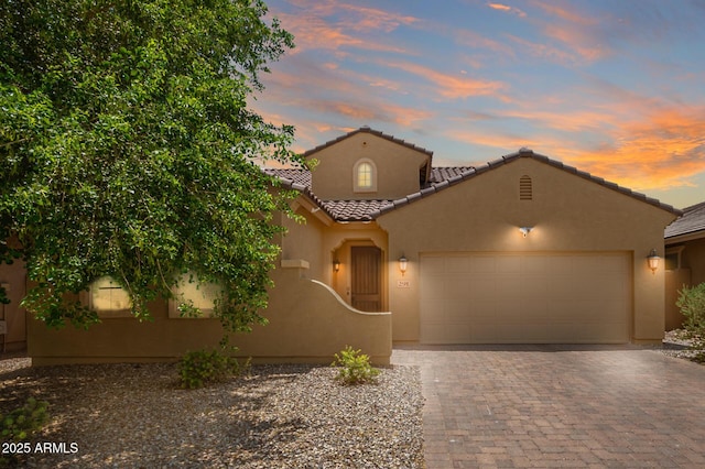 291 E Canyon Rock Rd, San Tan Valley, AZ 85143 - mediterranean / spanish-style house with stucco siding, decorative driveway, a tiled roof, and a garage